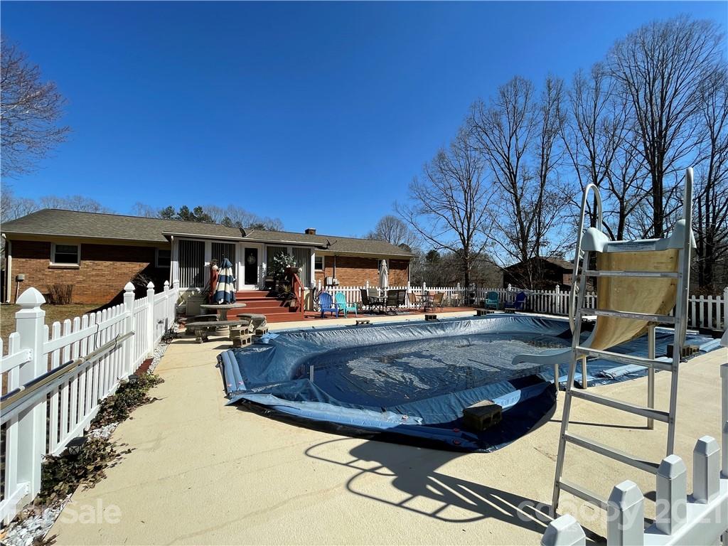 180 Watergate Drive Alexis, NC 28006 - Photo 4 of 40 a view of a patio with couches table and chairs with wooden floor and fence