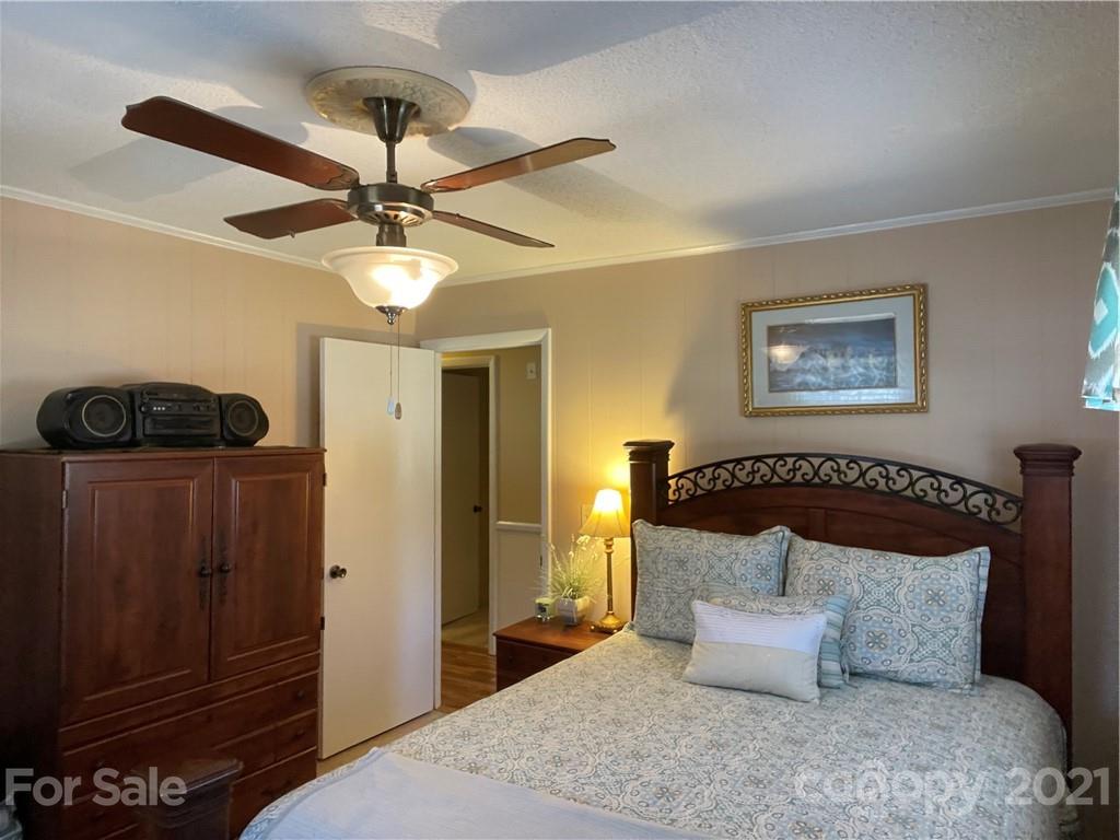 180 Watergate Drive Alexis, NC 28006 - Photo 31 of 40 a bedroom with a bed and a chandelier