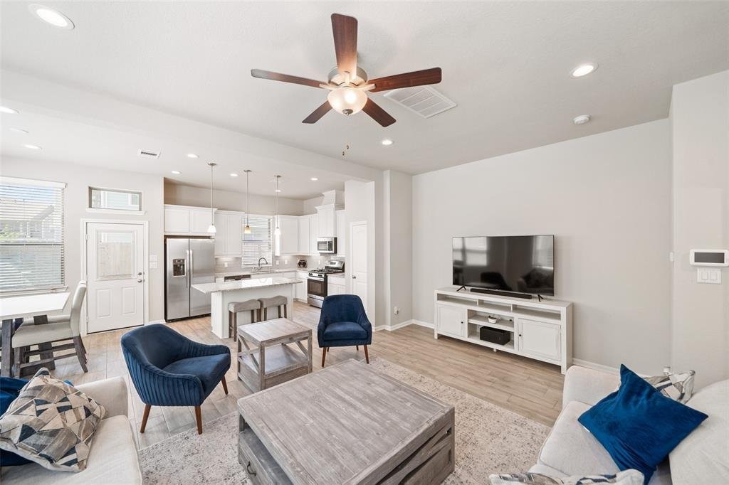 4241 Merry Mill Drive Spring, TX 77386 - Photo 4 of 24 a living room with furniture a flat screen tv and kitchen view