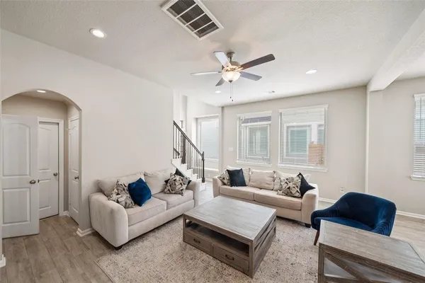 a living room with furniture and a wooden floor