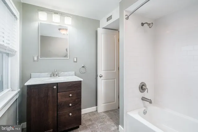 a bathroom with a tub sink and mirror