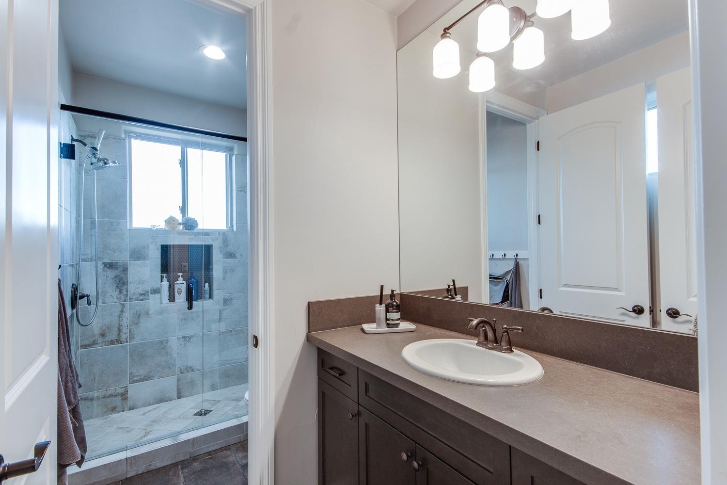 1437 Jordan Avenue Clovis, CA 93611 - Photo 33 of 53 a bathroom with a sink a mirror and a shower