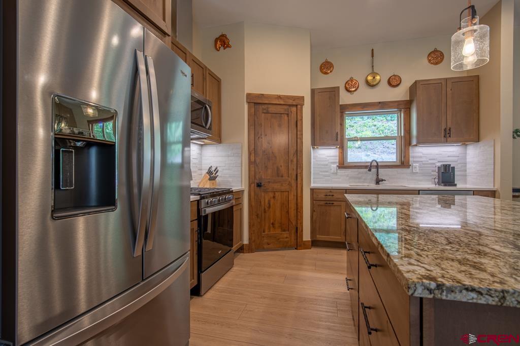 62 Manitou Lane Durango, CO 81301 - Photo 7 of 34 a kitchen with stainless steel appliances granite countertop a refrigerator a stove and a sink