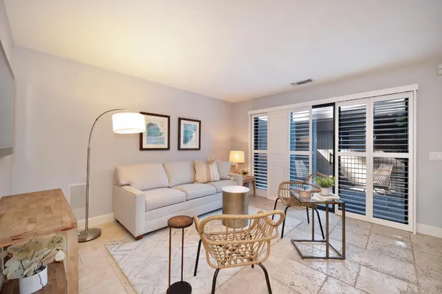a living room with furniture a table and a large window