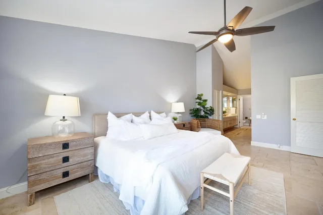 a bedroom with a bed a chandelier and a dresser