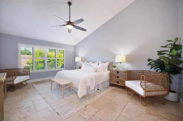 a spacious bedroom with a bed and a chandelier