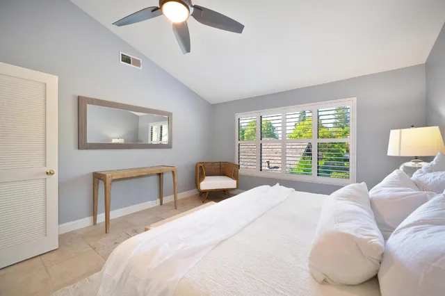 a bedroom with a large bed and a chandelier