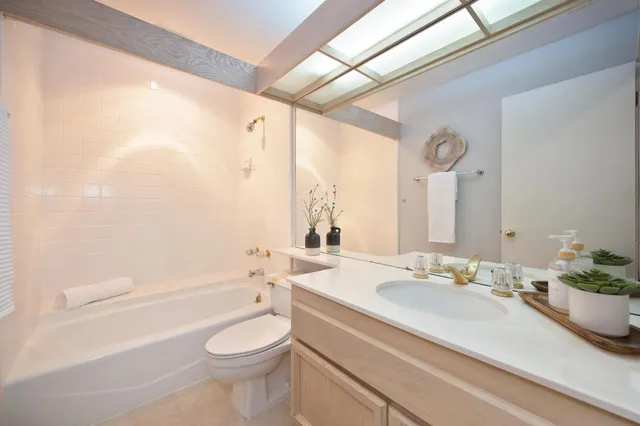 a bathroom with a sink a toilet and a large mirror