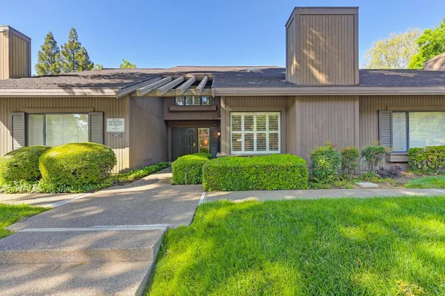a view of a house with a small yard and plants