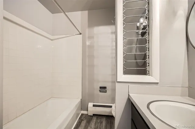 a bathroom with a granite countertop sink a toilet and shower