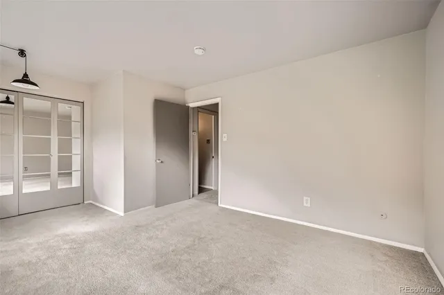 an empty room with windows and closet