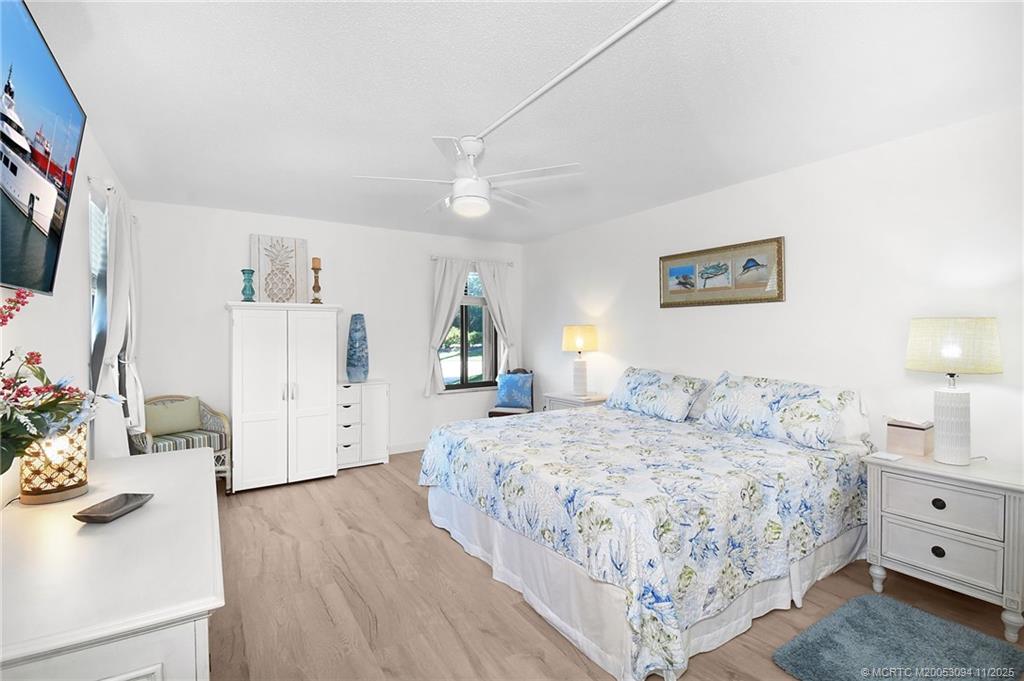 5111 Southeast Miles Grant Road, Unit 103 Stuart, FL 34997 - Photo 25 of 59 a bedroom with a bed and a flat screen tv
