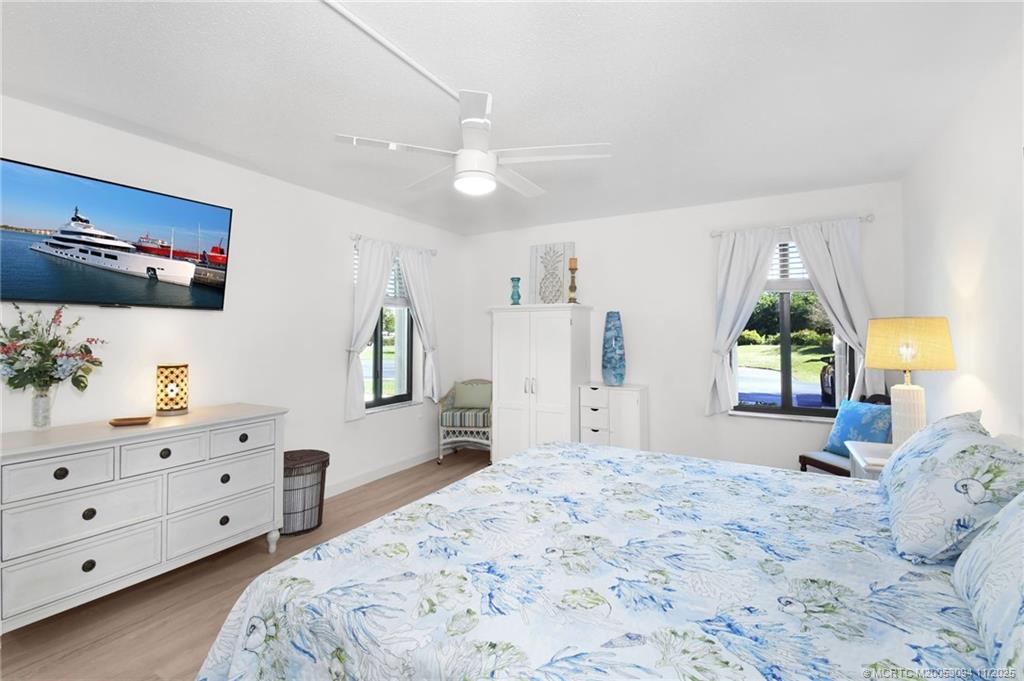 5111 Southeast Miles Grant Road, Unit 103 Stuart, FL 34997 - Photo 26 of 59 a bedroom with a bed and a dresser