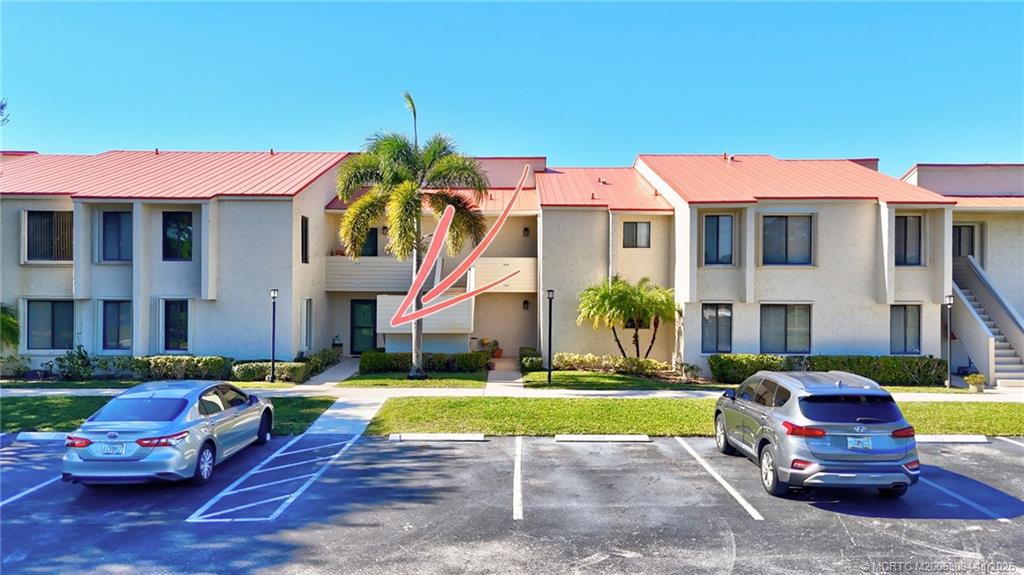 5111 Southeast Miles Grant Road, Unit 103 Stuart, FL 34997 - Photo 30 of 59 a view of a big house with swimming pool lawn chairs and a yard