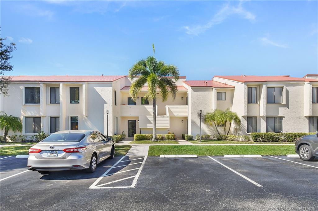 5111 Southeast Miles Grant Road, Unit 103 Stuart, FL 34997 - Photo 3 of 59 a view of a cars park in front of a building