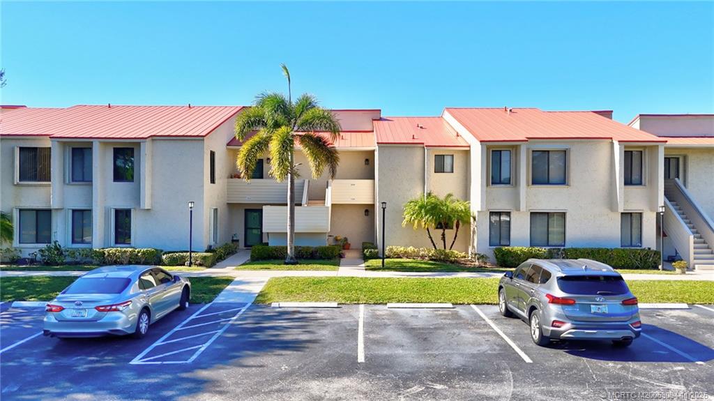 5111 Southeast Miles Grant Road, Unit 103 Stuart, FL 34997 - Photo 31 of 59 a view of a big house with swimming pool lawn chairs and a yard