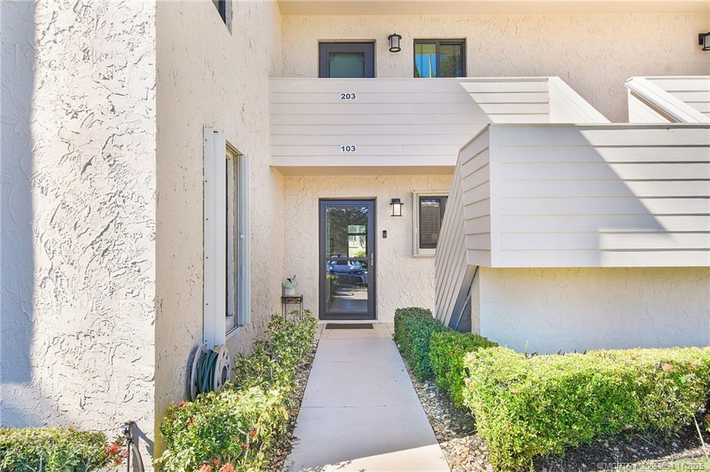 5111 Southeast Miles Grant Road, Unit 103 Stuart, FL 34997 - Photo 4 of 59 a front view of a house with garden