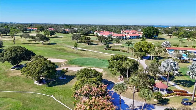 an aerial view of residential houses with outdoor space and trees