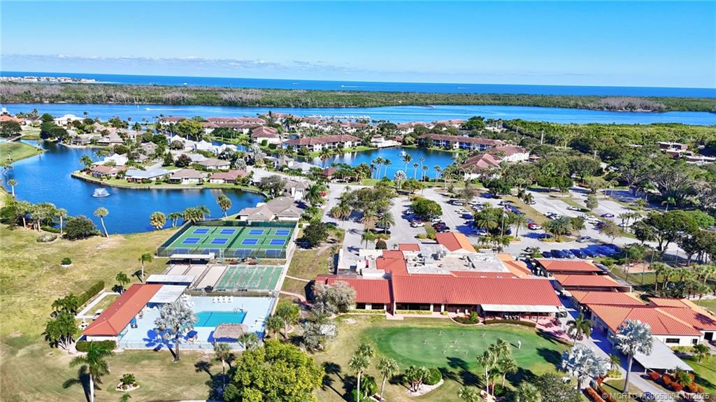 5111 Southeast Miles Grant Road, Unit 103 Stuart, FL 34997 - Photo 47 of 59 an aerial view of a city with lots of residential buildings and ocean view in back