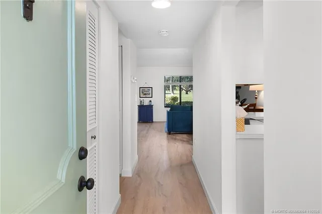 a view of a hallway with wooden floor and windows