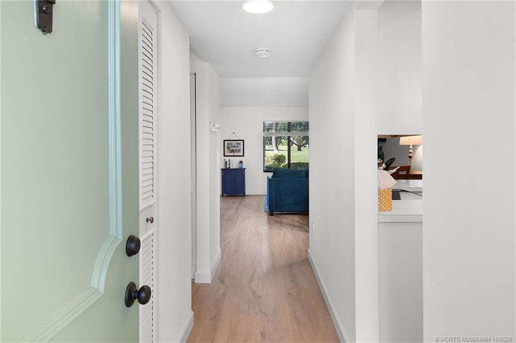 5111 Southeast Miles Grant Road, Unit 103 Stuart, FL 34997 - Photo 5 of 59 a view of a hallway with wooden floor and windows
