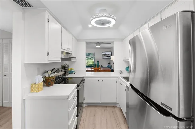 a kitchen with stainless steel appliances a refrigerator and a stove top oven