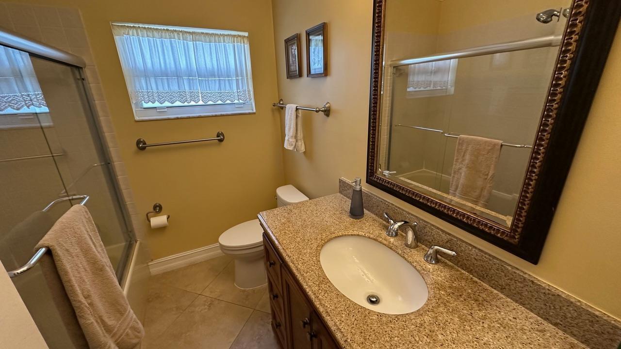 6594 Casabella Lane Boca Raton, FL 33433 - Photo 12 of 28 a bathroom with a granite countertop sink toilet and shower a mirror