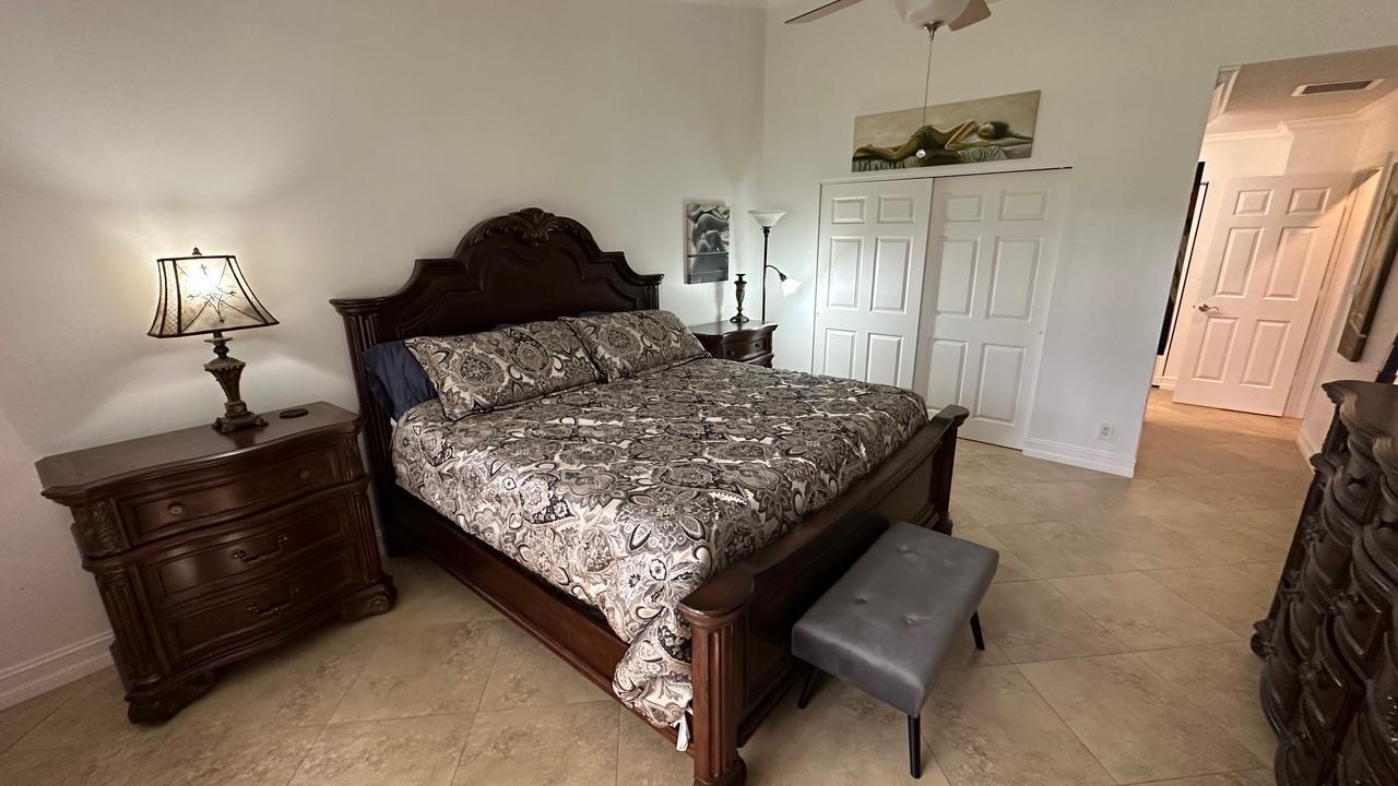 6594 Casabella Lane Boca Raton, FL 33433 - Photo 13 of 28 a bedroom with a bed and wooden floor