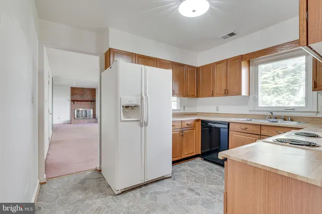 a kitchen with a refrigerator a stove a sink and a window