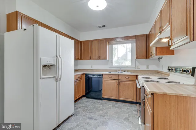 a kitchen with stainless steel appliances granite countertop a refrigerator sink and cabinets