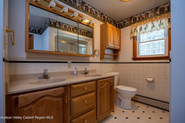 a bathroom with a sink mirror vanity and toilet