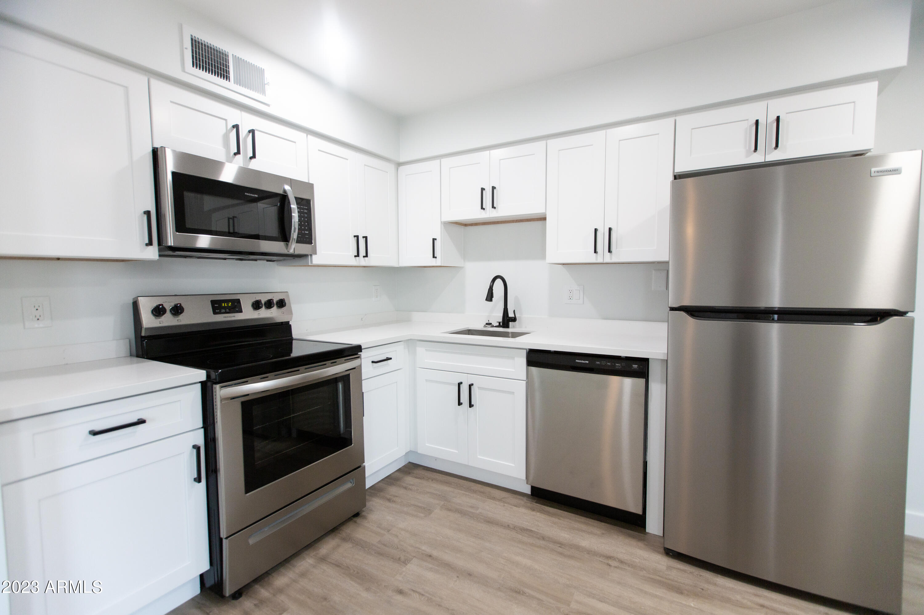 a kitchen with stainless steel appliances a refrigerator stove microwave and sink