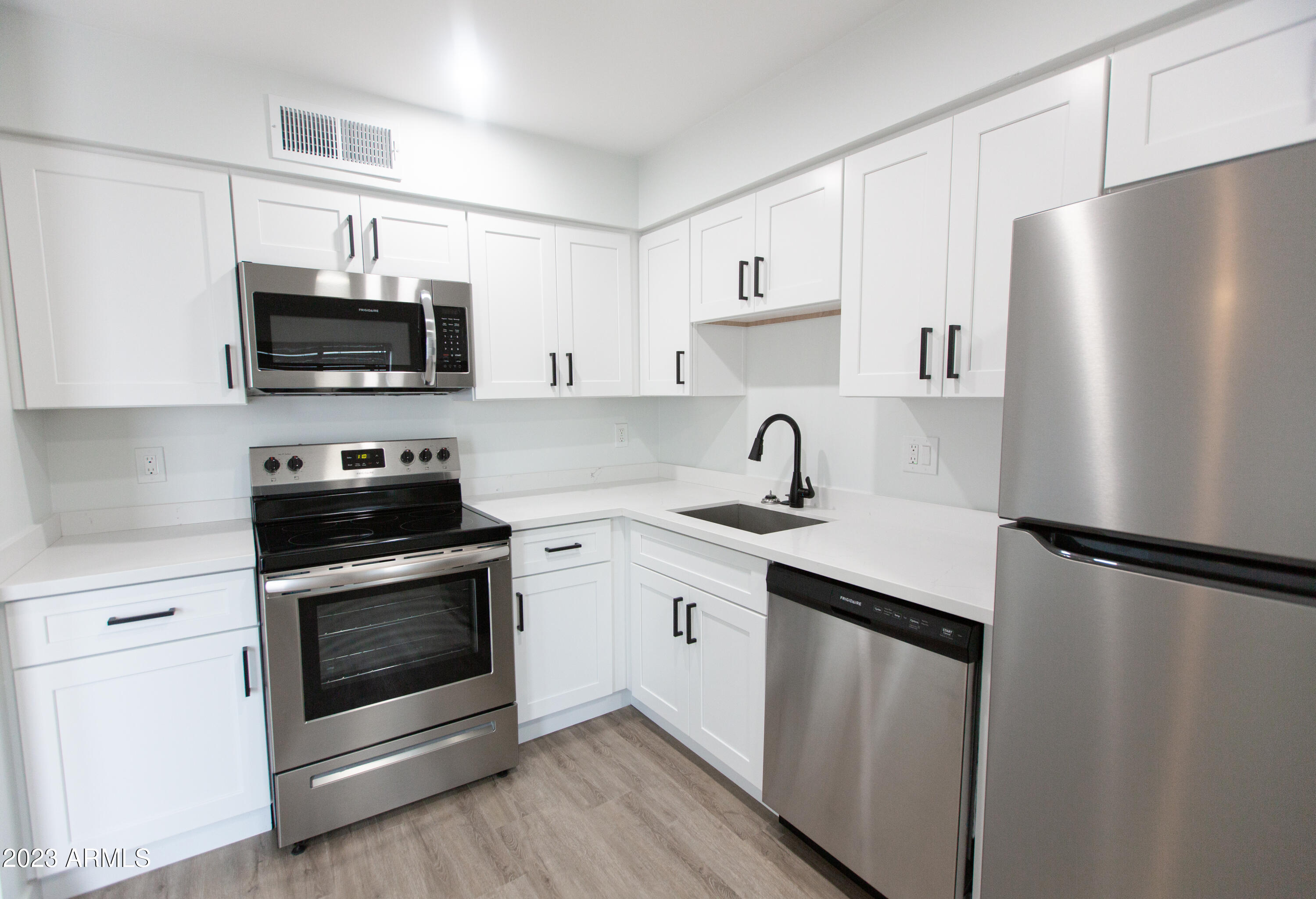 3133 East Fairmount Avenue Phoenix, AZ 85016 - Photo 2 of 11 a kitchen with stainless steel appliances a refrigerator sink and microwave