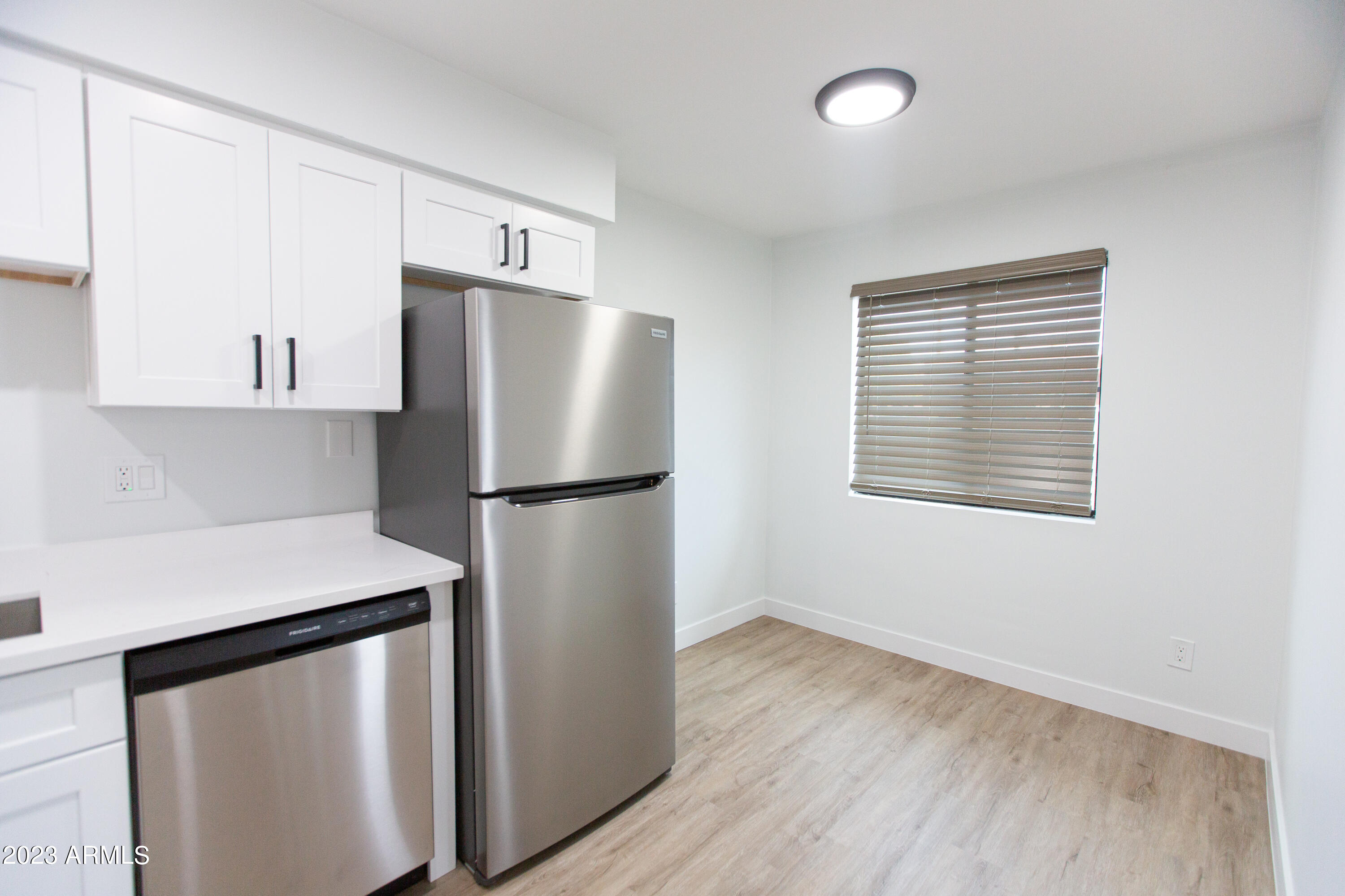 3133 East Fairmount Avenue Phoenix, AZ 85016 - Photo 3 of 11 a kitchen with metallic refrigerator and wooden floor
