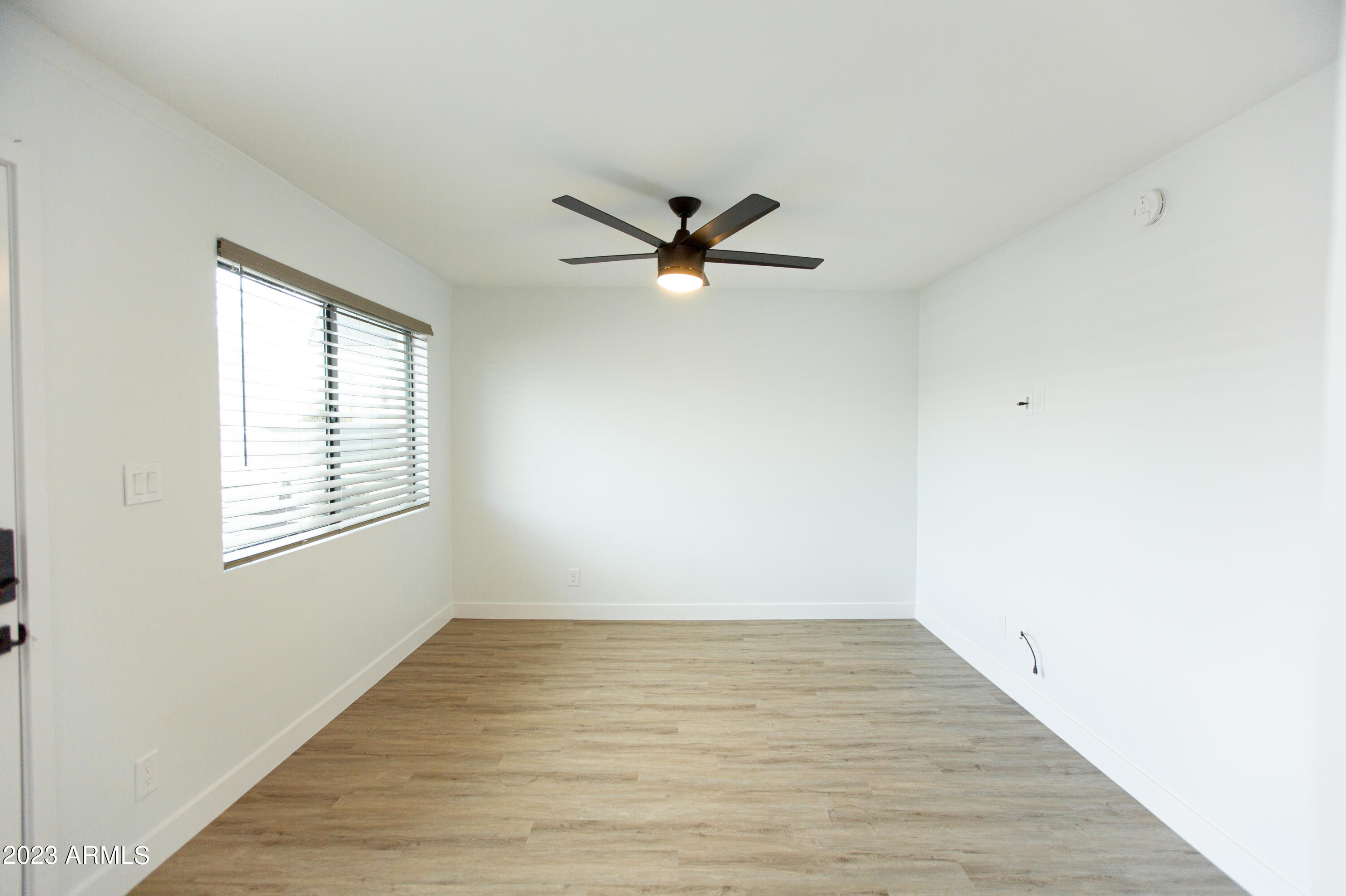 3133 East Fairmount Avenue Phoenix, AZ 85016 - Photo 5 of 11 an empty room with wooden floor and windows
