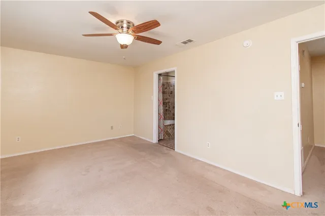 an empty room with closet and ceiling fan