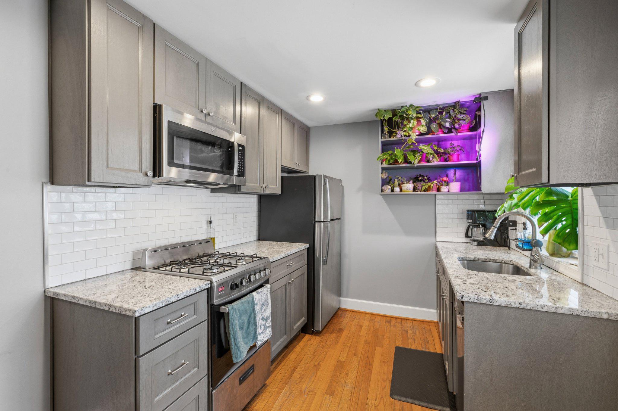 465 West South Street Frederick, MD 21701 - Photo 7 of 34 a kitchen with granite countertop stainless steel appliances a sink stove top oven and microwave