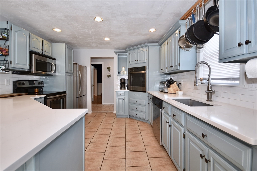 32 Gault Road Wareham, MA 02576 - Photo 4 of 23 a kitchen with stainless steel appliances granite countertop a sink a stove top oven a refrigerator cabinets and chairs