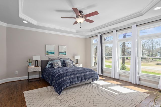 a bed sitting in a spacious bedroom next to a window