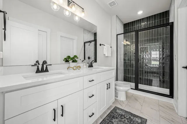 a bathroom with a double vanity sink mirror and shower
