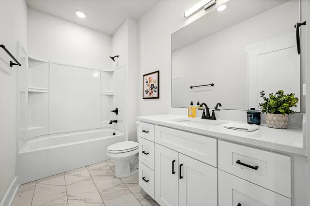 a bathroom with a double vanity sink toilet and shower