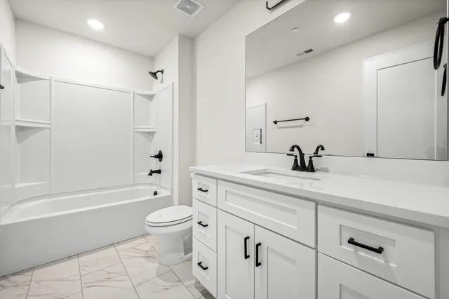 a bathroom with a sink a toilet and a large mirror