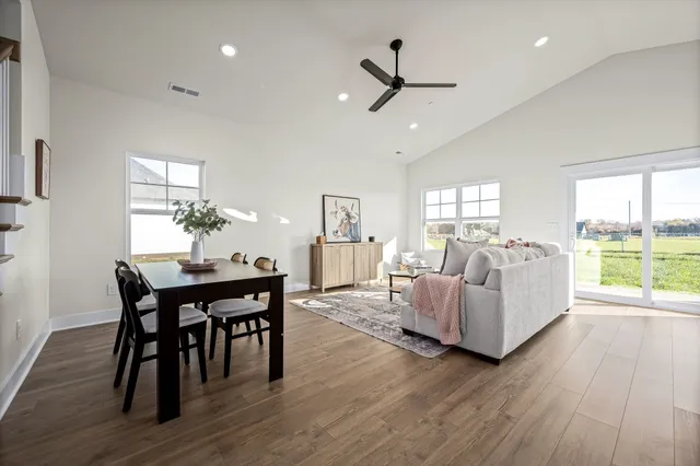 a living room with furniture dining table and a large window