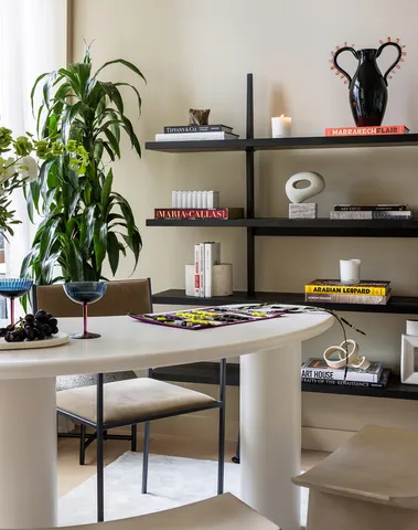 a living room with furniture a large window and potted plants