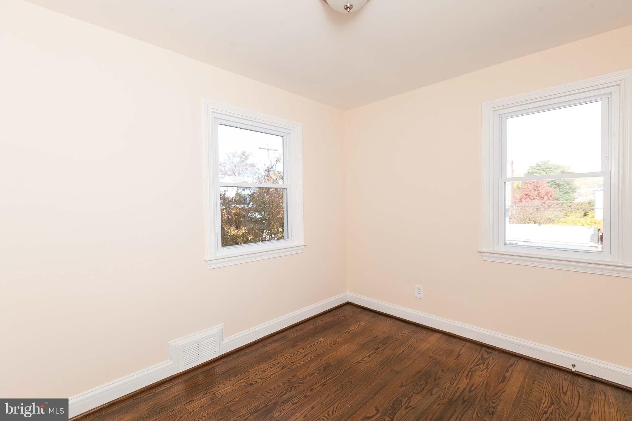 1316 East 35th Street Baltimore, MD 21218 - Photo 21 of 30 an empty room with wooden floor and windows