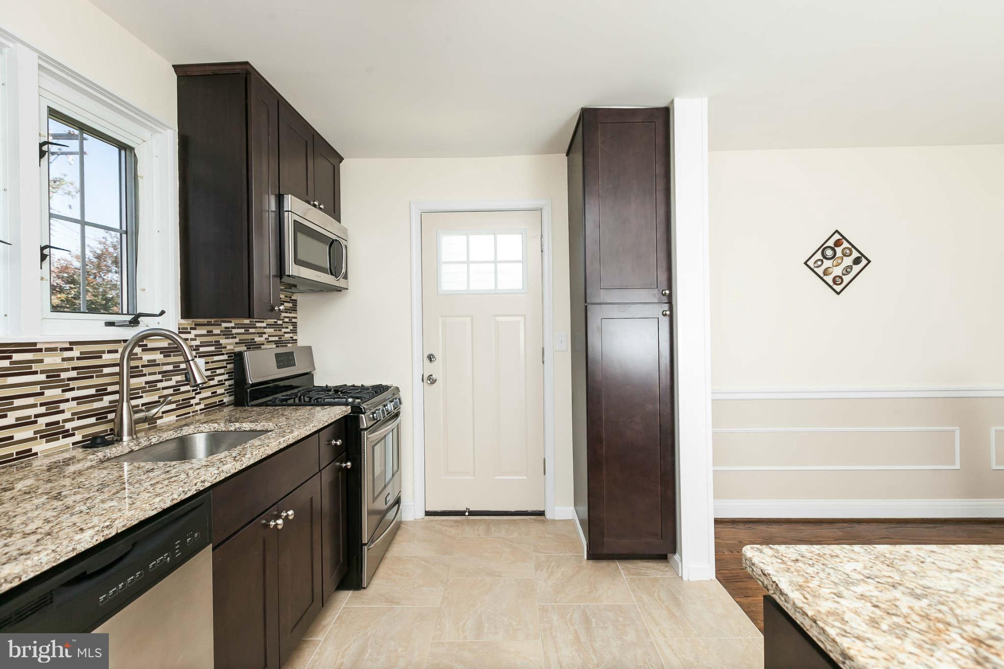 1316 East 35th Street Baltimore, MD 21218 - Photo 6 of 30 a kitchen with granite countertop stainless steel appliances a refrigerator and a sink
