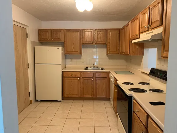 a kitchen with a refrigerator sink and cabinets