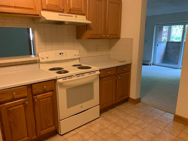 a kitchen with granite countertop white cabinets and white appliances