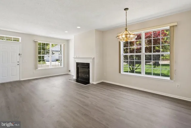 a view of empty room with wooden floor and fireplace