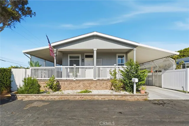 a front view of a house with a yard and potted plants